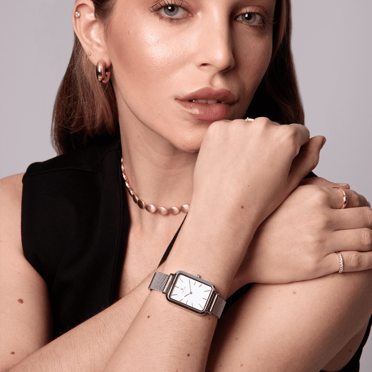 Relógio feminino Vanglore Lunna prata com fundo branco, caixa retangular e pulseira mesh, modelo usando