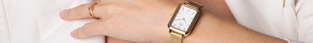 Mão feminina com anel dourado usando o relógio Vanglore Lunna dourado com pulseira de malha